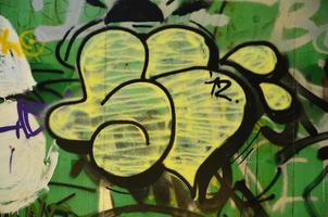 The old wall, painted in color graffiti drawing green aerosol paints. Background image on the theme of drawing graffiti and street art photo