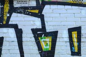 Fragment of graffiti drawings. The old wall decorated with paint stains in the style of street art culture. Colored background texture photo