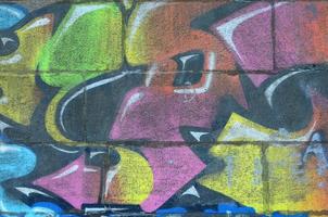 Fragment of graffiti drawings. The old wall decorated with paint stains in the style of street art culture. Multicolored background texture photo