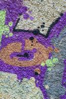 Fragment of graffiti drawings. The old wall decorated with paint stains in the style of street art culture. Colored background texture in warm tones photo