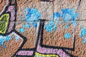 fragmento de dibujos de graffiti. la antigua muralla decorada con manchas de pintura al estilo de la cultura del arte callejero. textura de fondo coloreada en tonos cálidos foto