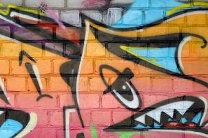 Abstract colorful fragment of graffiti paintings on old brick wall. Street art composition with parts of unwritten letters and multicolored stains. Subcultural background texture photo