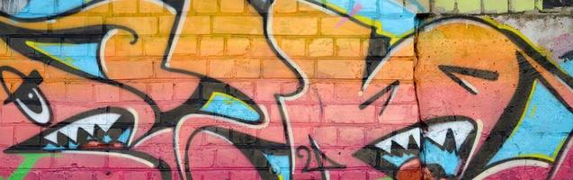 Abstract colorful fragment of graffiti paintings on old brick wall. Street art composition with parts of unwritten letters and multicolored stains. Subcultural background texture photo