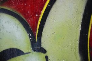 Texture of a fragment of the wall with graffiti painting, which is depicted on it. An image of a piece of graffiti drawing as a photo on street art and graffiti culture topics