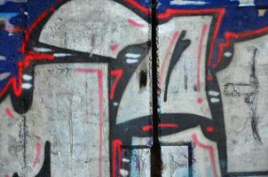 Texture of a fragment of the wall with graffiti painting, which is depicted on it. An image of a piece of graffiti drawing as a photo on street art and graffiti culture topics