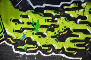 The old wall, painted in color graffiti drawing green aerosol paints. Background image on the theme of drawing graffiti and street art photo