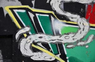 Texture of a fragment of the wall with graffiti painting, which is depicted on it. An image of a piece of graffiti drawing as a photo on street art and graffiti culture topics