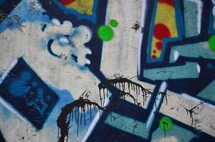 Texture of a fragment of the wall with graffiti painting, which is depicted on it. An image of a piece of graffiti drawing as a photo on street art and graffiti culture topics