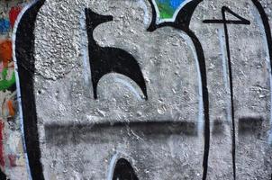 Texture of a fragment of the wall with graffiti painting, which is depicted on it. An image of a piece of graffiti drawing as a photo on street art and graffiti culture topics