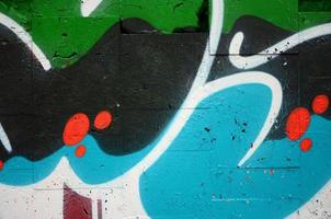 A fragment of graffiti drawing using contours, applied to the wall with the help of cans with aerosol paints over the colored filling areas. Background texture of street art and vandalism photo