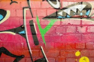 Abstract colorful fragment of graffiti paintings on old brick wall. Street art composition with parts of unwritten letters and multicolored stains. Subcultural background texture photo