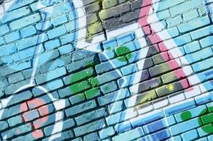 fragmento de dibujos de graffiti. la antigua muralla decorada con manchas de pintura al estilo de la cultura del arte callejero. textura de fondo coloreada en tonos fríos foto