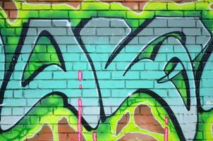 Fragment of graffiti drawings. The old wall decorated with paint stains in the style of street art culture. Colored background texture in green tones photo