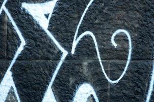 Fragment of graffiti drawings. The old wall decorated with paint stains in the style of street art culture. Colored background texture photo