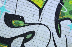Fragment of graffiti drawings. The old wall decorated with paint stains in the style of street art culture. Colored background texture in green tones photo