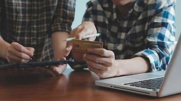 mãos segurando um cartão de crédito e usando o laptop. compras online video