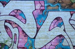 Fragment of graffiti drawings. The old wall decorated with paint stains in the style of street art culture. Colored background texture in purple tones photo