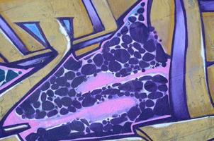 Fragment of graffiti drawings. The old wall decorated with paint stains in the style of street art culture. Colored background texture in purple tones photo