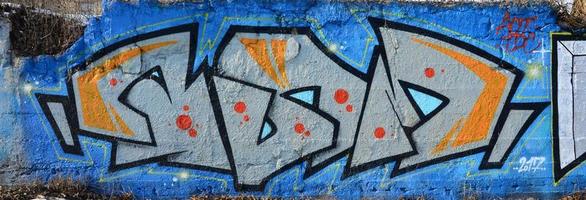 The old wall, painted in color graffiti drawing blue aerosol paints. Background image on the theme of drawing graffiti and street art photo