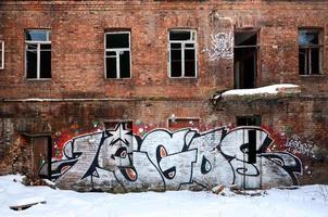 The old wall, painted in color graffiti drawing red aerosol paints. Background image on the theme of drawing graffiti and street art photo