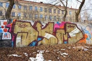 The old wall, painted in color graffiti drawing red aerosol paints. Background image on the theme of drawing graffiti and street art photo