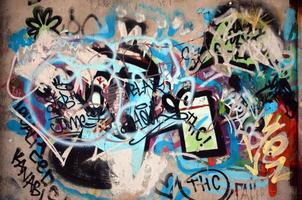 fragmento de primer plano de un dibujo de graffiti aplicado a la pared con pintura en aerosol. la pared está estropeada por una multitud de firmas coloridas y etiquetas de artistas callejeros y hooligans foto