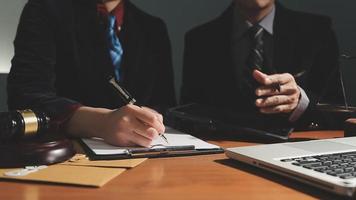 zaken en advocaten bespreken contractpapieren met koperen schaal op bureau in kantoor. wet, juridische diensten, advies, rechtvaardigheid en wet concept foto met film grain effect video