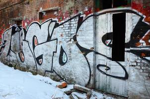 The old wall, painted in color graffiti drawing red aerosol paints. Background image on the theme of drawing graffiti and street art photo