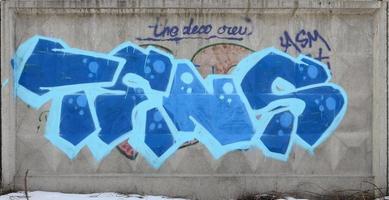 The old wall, painted in color graffiti drawing blue aerosol paints. Background image on the theme of drawing graffiti and street art photo