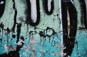 Texture of a fragment of the wall with graffiti painting, which is depicted on it. An image of a piece of graffiti drawing as a photo on street art and graffiti culture topics