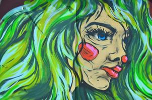 The old wall, painted in color graffiti drawing with aerosol paints. Image of the face of an informal girl with green lush hair photo