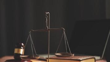 Business and lawyers discussing contract papers with brass scale on desk in office. Law, legal services, advice, justice and law concept picture with film grain effect video