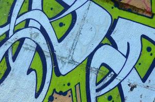 Fragment of graffiti drawings. The old wall decorated with paint stains in the style of street art culture. Colored background texture in green tones photo
