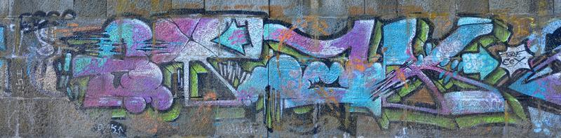 Fragment of graffiti drawings. The old wall decorated with paint stains in the style of street art culture. Colored background texture in cold tones photo