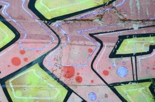 Fragment of graffiti drawings. The old wall decorated with paint stains in the style of street art culture. Colored background texture in warm tones photo
