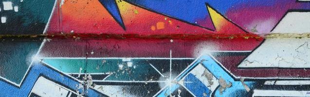 Fragment of graffiti drawings. The old wall decorated with paint stains in the style of street art culture. Multicolored background texture photo