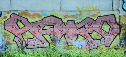 fragmento de dibujos de graffiti. la antigua muralla decorada con manchas de pintura al estilo de la cultura del arte callejero. textura de fondo coloreada en tonos cálidos foto