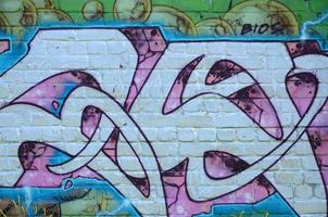 Fragment of graffiti drawings. The old wall decorated with paint stains in the style of street art culture. Colored background texture in purple tones photo