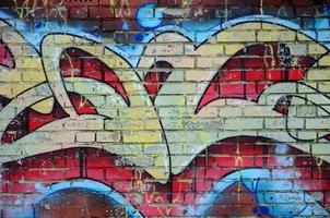 Fragment of graffiti drawings. The old wall decorated with paint stains in the style of street art culture. Colored background texture in warm tones photo