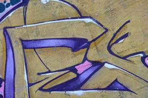 Fragment of graffiti drawings. The old wall decorated with paint stains in the style of street art culture. Colored background texture in purple tones photo