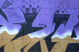 Fragment of graffiti drawings. The old wall decorated with paint stains in the style of street art culture. Colored background texture in purple tones photo