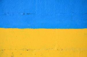 Fragment of graffiti drawings. The old wall decorated with paint stains in the style of street art culture. Ukrainian flag photo