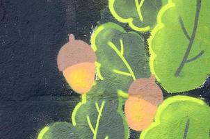 Fragment of graffiti drawings. The old wall decorated with paint stains in the style of street art culture. Oak leaves and acorns photo