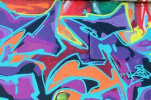 Fragment of graffiti drawings. The old wall decorated with paint stains in the style of street art culture. Multicolored background texture photo