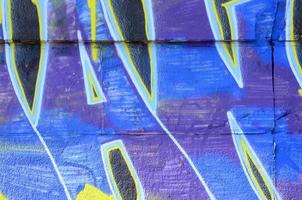 Fragment of graffiti drawings. The old wall decorated with paint stains in the style of street art culture. Colored background texture in cold tones photo