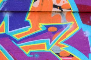 Fragment of graffiti drawings. The old wall decorated with paint stains in the style of street art culture. Colored background texture in purple tones photo