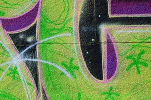 Fragment of graffiti drawings. The old wall decorated with paint stains in the style of street art culture. Colored background texture in green tones photo