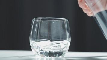 Wasser trinken. Die Hand der Frau gießt frisches, reines Wasser aus dem Krug in ein Glas. Gesundheits- und Ernährungskonzept. gesunder Lebensstil. Gesundheit und Schönheit. Hydratation. video