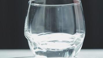 drinken water. vrouw hand- gieten vers zuiver water van werper in een glas. Gezondheid en eetpatroon concept. gezond levensstijl. gezondheidszorg en schoonheid. hydratatie. video