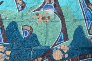 Fragment of graffiti drawings. The old wall decorated with paint stains in the style of street art culture. Colored background texture in cold tones photo
